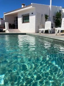 - une piscine d'eau bleue en face d'une maison dans l'établissement PAULA, à Riumar