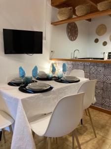 利烏馬的住宿－PAULA，餐桌、白色椅子和电视