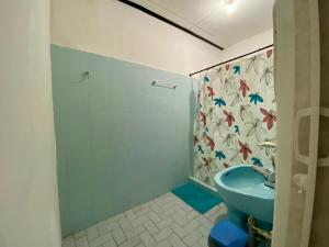 W łazience znajduje się niebieska toaleta i prysznic. w obiekcie Habitación Multiple cerca de aeropuerto w mieście Cartagena de Indias