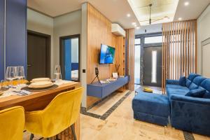 Una sala de estar con un sofá azul y una mesa. en Florance Rentals Luxury Apartments in Burgas, en Burgas