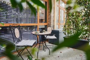 un patio con 2 sillas, una mesa y una ventana en Florance Rentals Luxury Apartments in Burgas, en Burgas