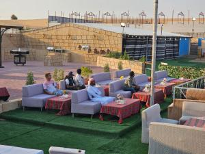 eine Gruppe von Personen, die auf Sofas und Tischen sitzen in der Unterkunft Desert Safari Dubai Over Night Stay in Hunaywah