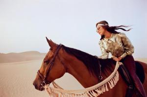 Eine Frau reitet ein Pferd in der Wüste in der Unterkunft Desert Safari Dubai Over Night Stay in Hunaywah