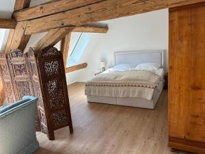 a bedroom with a bed and a wooden floor at Historische Mühle von Cramm in Ballrechten-Dottingen