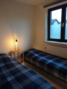 two beds in a room with a window at Surrender three bedrooms in Houthalen-Helchteren