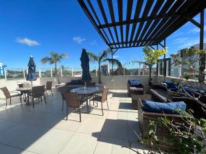 un patio con tavoli, sedie e ombrelloni di Charrua Hotel a Santa Cruz do Sul