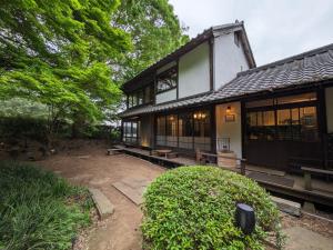 ein Haus mit vielen Fenstern und einem Hof in der Unterkunft Antique Villa Lotus（古民家ロータス） in Tsukuba