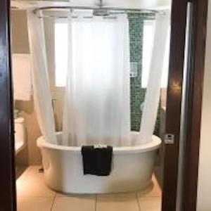 a bathroom with a shower and a white tub at Congress Ocean Drive in Miami Beach +18 photos