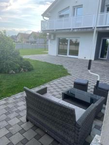 un patio con 2 sillas y un banco frente a una casa en Apartment Adi, en Slavonski Brod