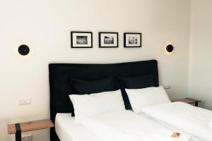 a bedroom with two white beds and three pictures on the wall at Ferienwohnung Frickenhausen am Main in Frickenhausen