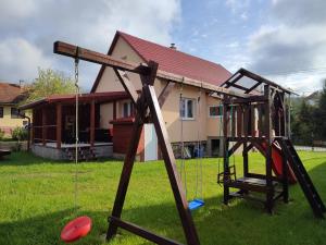 a swing set in a yard in front of a house at Privat ZUZANA in Prosiek