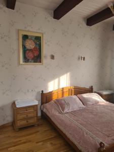 1 dormitorio con 1 cama y una pintura en la pared en Kranto Vila en Kaunas