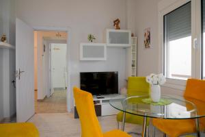 sala de estar con mesa de cristal y sillas amarillas en B&G Beach bliss apartment, en Nea Iraklia