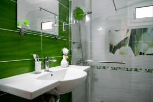 Un baño con un lavabo blanco y un espejo. en B&G Beach bliss apartment, en Nea Iraklia 7 fotos más