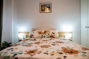 Un dormitorio con una cama con un edredón floral. en B&G Beach bliss apartment, en Nea Iraklia