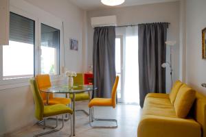 una sala de estar con un sofá, una mesa y sillas en B&G Beach bliss apartment, en Nea Iraklia