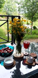 a table with a vase of flowers and a bowl of fruit at Near Yerevan Serlinhouse in Oshakan