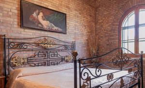ein Schlafzimmer mit einem Bett und einem Gemälde an einer Backsteinwand in der Unterkunft B & B Torre Saracena in Mattinata