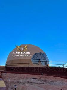 un grande edificio a cupola con un cartello sopra di MARS LUXURY CAMP WADi RUM a Wadi Rum