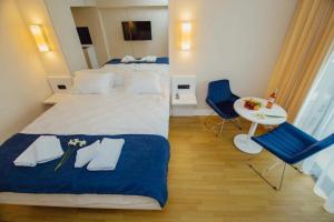 een slaapkamer met een groot bed en 2 blauwe stoelen bij ORBI CITY SUITE in Batoemi