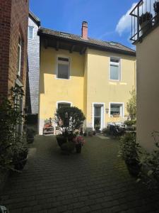 a yellow house with a brick courtyard in front of it at small Stable - charmantes Häuschen Mitten in Lemgo in Lemgo