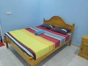 - un lit avec des draps et des oreillers colorés dans l'établissement Moorthy House, à Kankesanturai