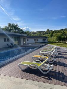 a row of lounge chairs lined up next to a swimming pool at ALL SEASONS in Feleacu