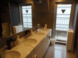 baño con 2 lavabos y espejo grande en The Nell Ueno Okachimachi, en Tokio