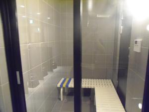 a shower stall with a bench in a bathroom at The Nell Ueno Okachimachi in Tokyo