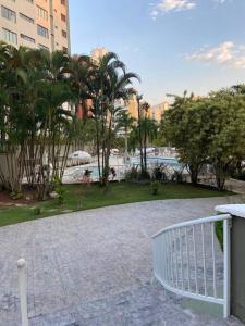 ein Gehweg, der zu einem Park mit Palmen und Gebäuden führt in der Unterkunft Plaza Riviera - Módulo 6 - 2 Quartos - 300 metros da praia in Riviera de São Lourenço