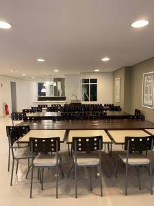 ein Esszimmer mit Tischen und Stühlen und einer Bar in der Unterkunft Plaza Riviera - Módulo 6 - 2 Quartos - 300 metros da praia in Riviera de São Lourenço + 38 Fotos