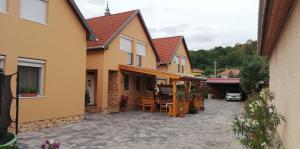 a courtyard of a house with chairs and tables at Ágica Vendégház in Andornaktálya