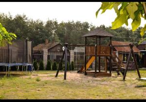a playground with a slide and a swing set at Садиба «Під ліском» in Pulʼmo