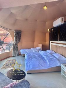 a bedroom with a blue bed and a window at RUM SUNRlSE LUXURY CAMP in Wadi Rum