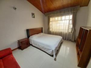 ein kleines Schlafzimmer mit einem Bett und einem Fenster in der Unterkunft Amplia Casa Familiar in Bogotá