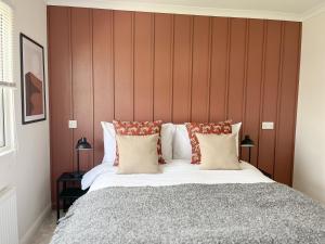 a bedroom with a large bed with a wooden headboard at Serenity Lodge, Riverside with Free Parking in Christchurch