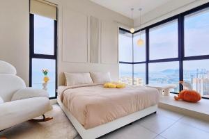 a bedroom with a bed with a large window at Tatami with Seaview, 9pax, Urban Suites by PG Home in George Town +67 photos