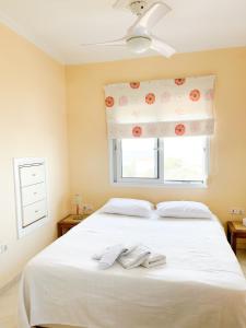 a bedroom with a white bed with a window at Family villa in Megalochori +7 photos