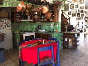 a kitchen with a red table and green tiles at Cabaña Tiriskua Eco Retreat / 15 Min del Metropolitano Leon Gto in León