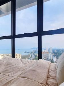 a bed in a room with a large window at Tatami with Seaview, 9pax, Urban Suites by PG Home in George Town