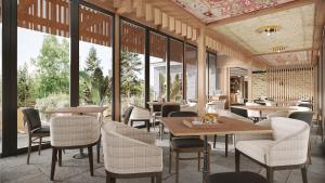 un restaurante con mesas, sillas y ventanas en Historic Rocky Waters Inn, A Small Luxury Hotel, en Gatlinburg