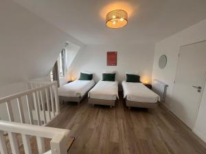 Habitación con 3 camas y escalera. en La Résidence Alpha Viroflay 302 - Duplex 2 chambres - 5 pers, en Viroflay