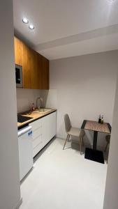 uma pequena cozinha com uma mesa e uma cadeira em Host Apartament Elio em Tirana