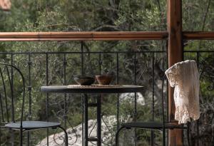a table on a balcony with two cups on it at Kynthia Hotel - Adults Only in Kalogria