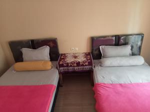 two beds sitting next to each other in a room at Rinjani home stay 02 in Senaru