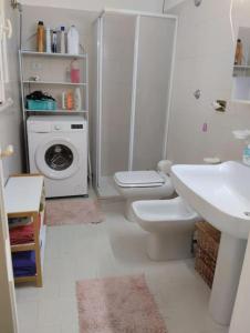 een badkamer met toilet en wasmachine bij Casa al mare in centro a 100 metri dalla spiaggia con terrazza in Torre Santa Sabina +33 foto's