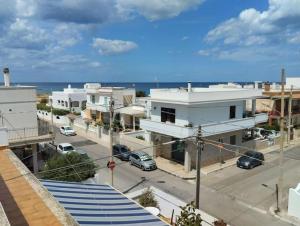 uitzicht op een straat met gebouwen en de oceaan bij Casa al mare in centro a 100 metri dalla spiaggia con terrazza in Torre Santa Sabina