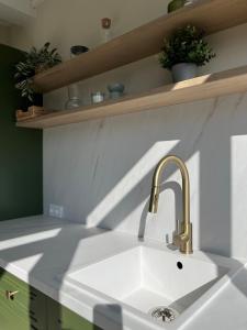 a white kitchen with a sink and a counter at Crossroads Cabin in Sălişte