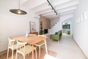 a dining room and living room with a table and chairs at Casa con historia en el centro. in Castellón de la Plana