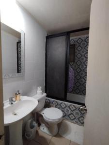 a bathroom with a toilet and a sink at Hotel Aurora in Coronel